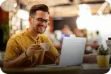Man drinking a coffe in front of a laptop